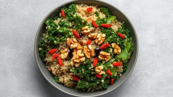 A bowl of quinoa salad with walnuts and red peppers photo