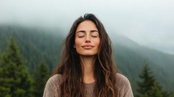 A woman is meditating in front of a mountain photo