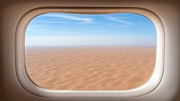 An airplane window looking out on a desert photo