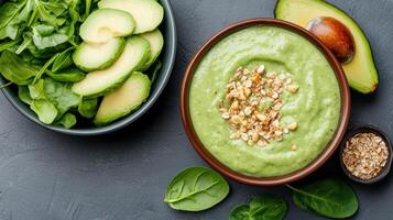 Avocado and spinach dip with nuts and seeds on a dark background photo