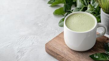 A cup of green matcha tea on a wooden cutting board photo