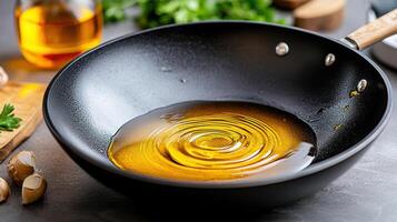 A frying pan with oil and garlic photo