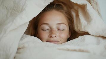 A woman is sleeping under a blanket photo
