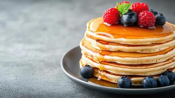 Stack of pancakes with berries and syrup photo