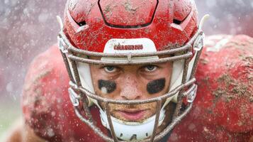 A football player in the rain with mud on his face photo