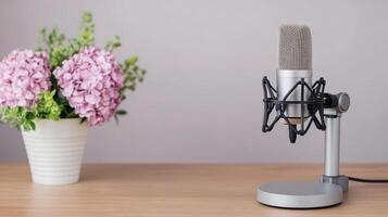 A microphone and flowers on a wooden table photo