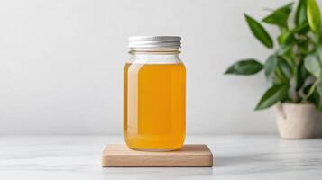 A glass bottle of orange juice on a wooden stand photo