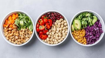 Three bowls of different colored vegetables and beans photo