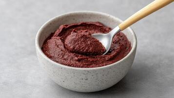 A spoon is in a bowl of beetroot paste photo