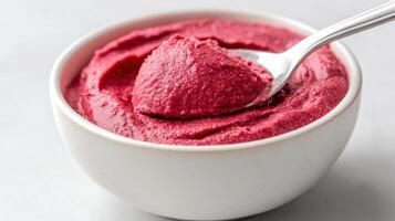 A spoonful of raspberry ice cream in a bowl photo