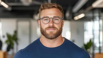 A man with glasses and beard in an office photo