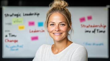 A woman is smiling in front of a whiteboard photo
