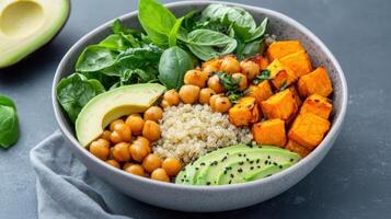 Healthy sweet potato and chickpea quinoa bowl with avocado and spinach photo