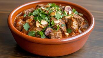 A bowl of meat and vegetables with herbs photo