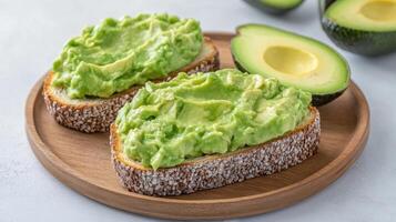 Avocado toast on a wooden plate with avocado spread photo