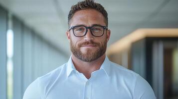 Confident man with glasses wearing white shirt in modern office setting photo