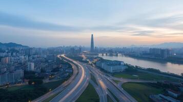 Aerial view of city skyline at dusk, featuring illuminated roads and river photo