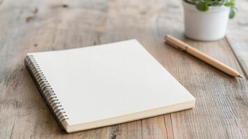 blank notebook on wooden table with pen and small potted plant, inviting creativity photo