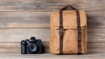 A brown backpack and camera on a wooden background photo