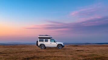 Land rover defender 110 on a hillside at sunset photo