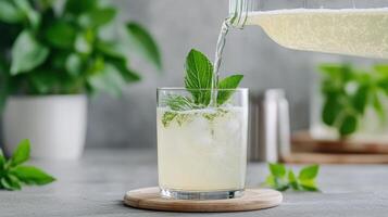 A glass of lemonade being poured into a glass photo