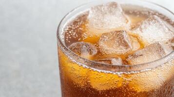 A glass of cola with ice cubes photo