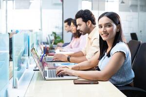 Female Administrator Sitting In Office Smiling While Looking At Camera photo
