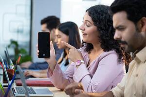 Woman Holding And Pointing At Phone photo