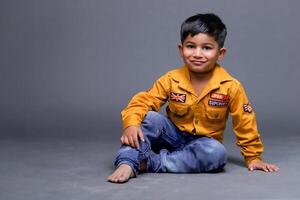 A Happy Smiling Kid Is Posing While Sitting On Floor photo