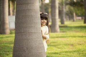 Female Child Peeping Out From Behind The Tree photo