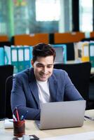Business Person Looking At Laptop Screen And Smiling photo