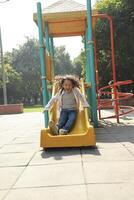 Cute Boy Playing On The Slider Bar At The Playground photo