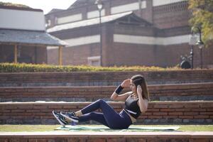 Fit Woman Doing Elbow To Knee Crunches Workout In Park photo