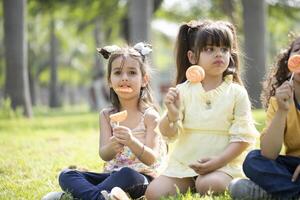 Three Little Friends Eating Lollipop photo