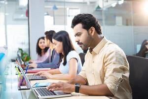 Young Talent Sitting In Row And Working Together With His Team In Office photo