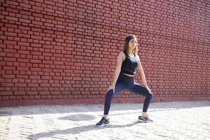 Front Pose Of Beautiful Woman Performing Leg Squat Exercise photo