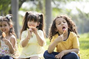 Kids Eating Colorful Lollipop While Posing In Front Of Camera photo