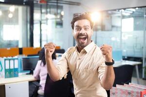 Joyful Team Member Punching The Air With His Fists With His Mouth Wide Open photo