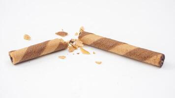 Rolled chocolate wafer cookies with a crunchy shell isolated on white background photo