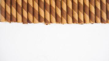 Chocolate wafer rolls arranged neatly isolated on white background photo