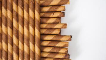 Sweet and crunchy chocolate wafer rolls in a neat arrangement isolated on white background photo