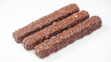Crispy caramel wafer bars covered in milk chocolate and rice crisps isolated on white background photo