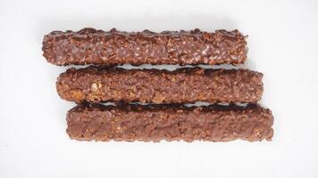 Chocolate coated caramel wafer bars with crunchy layers and puffed rice isolated on white background photo