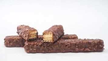 Golden caramel wafer bars wrapped in crispy wafers and chocolate coating isolated on white background photo