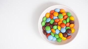 Delicious chocolate coated candies with a crunchy sugar shell in various colors isolated on white background photo