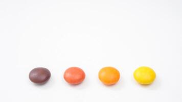 Thin crunchy sugar shell chocolate candies with a smooth cocoa filling isolated on white background photo