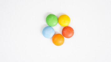 Rich chocolate center candies with a crispy and colorful sugar shell isolated on white background photo