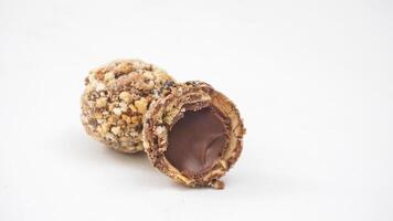 Rich chocolate truffles with a crunchy nut coating and soft chocolate center isolated on white background photo