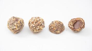 Chocolate truffles covered in finely chopped nuts with a creamy chocolate core isolated on white background photo