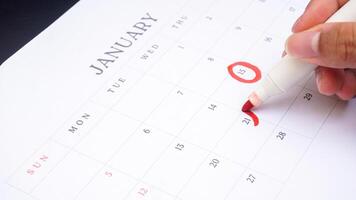 Red circle marked on a calendar at important dates isolated on black background photo